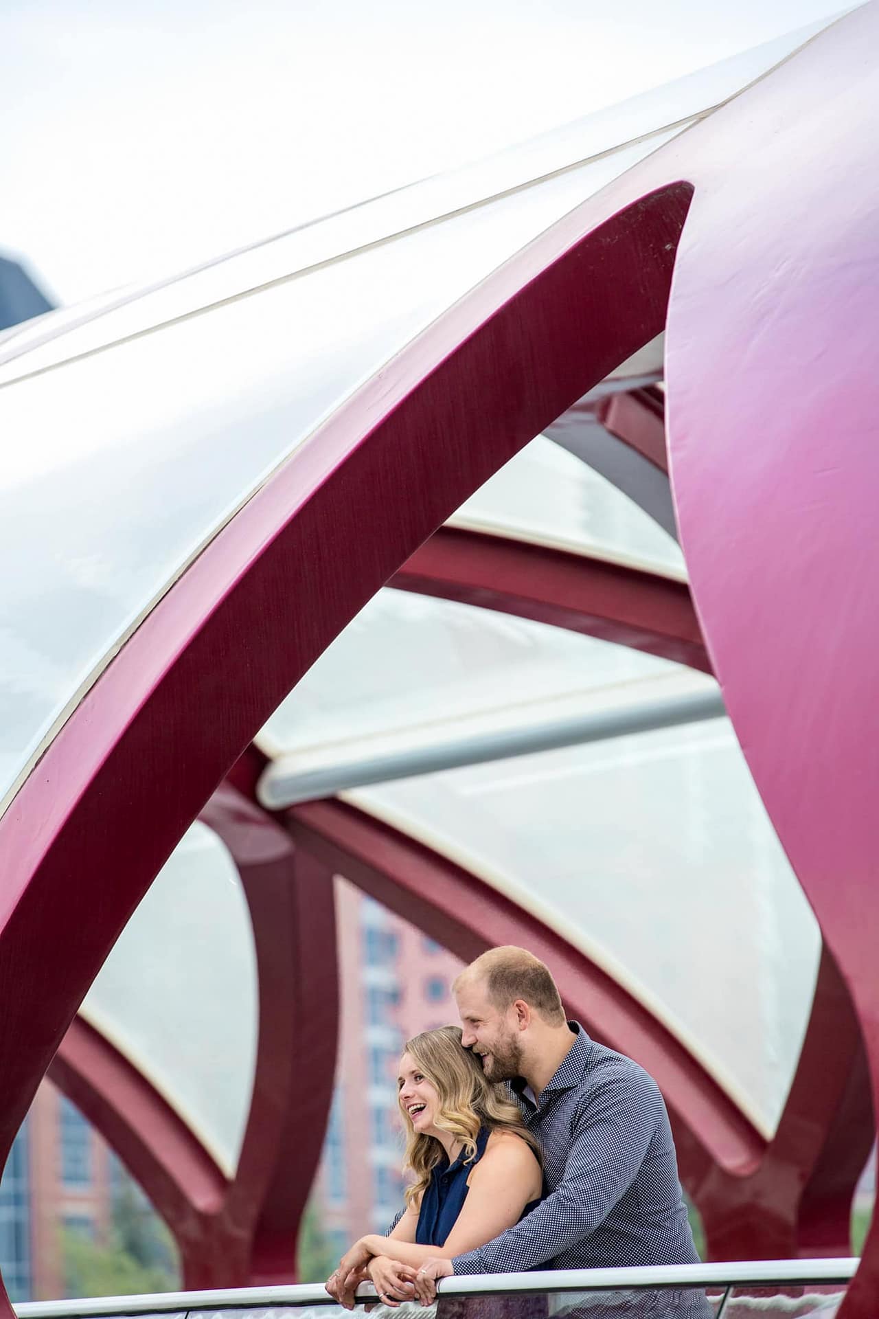 couple-laughs-during-engagement-session-calgary-peace-bridge