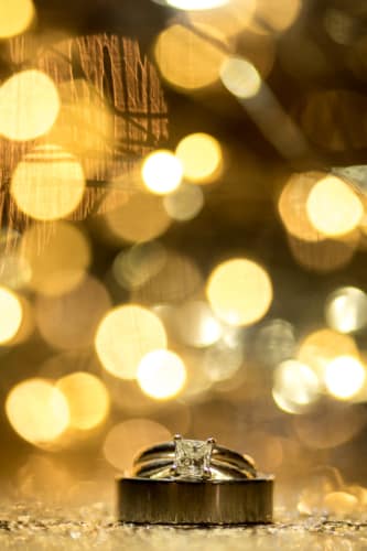 Wedding rings glitter with lights behind at a Calgary wedding