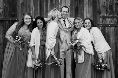 Sister kisses her brother on the cheek during photos at a Strathmore wedding