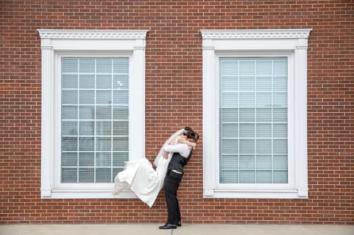 Groom picks up Bride as they celebrate their first look and upcoming marriage at a Calgary Wedding