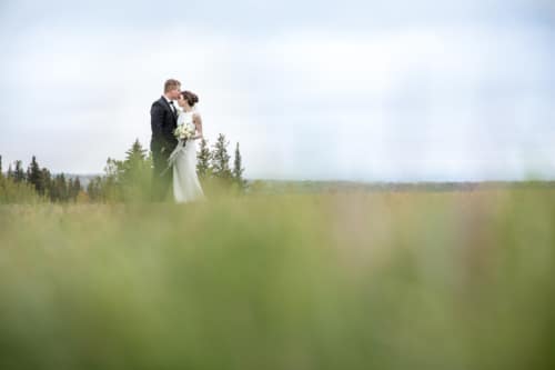 Groom kisses bride on forehead at Pinebrook Golf course Calgary Wedding